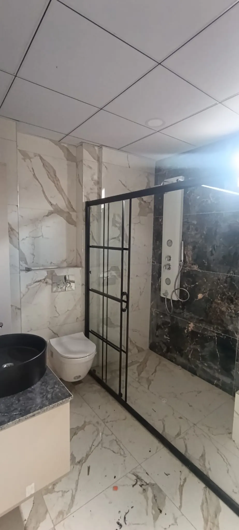Mersin’de Kahraman Yapı tarafından yapılan mermer desenli, cam bölmeli lüks banyo tadilatı