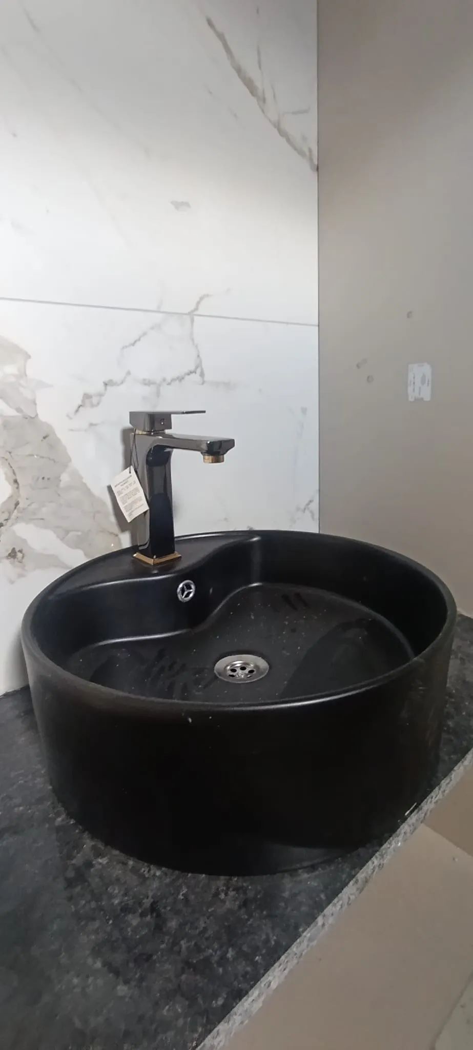 Siyah çanak lavabo ve altın detaylı armatür